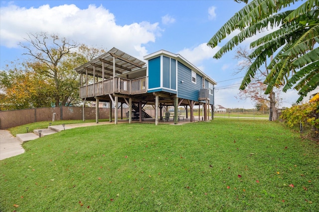 back of property featuring a wooden deck and a lawn