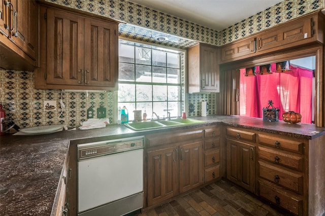 kitchen featuring kitchen peninsula, dishwasher, dark hardwood / wood-style floors, and sink