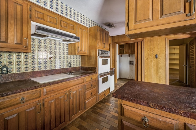 kitchen featuring white appliances and ventilation hood