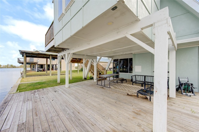 wooden terrace with a yard and a water view