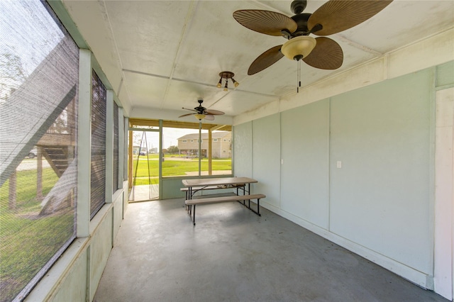 unfurnished sunroom with ceiling fan and plenty of natural light