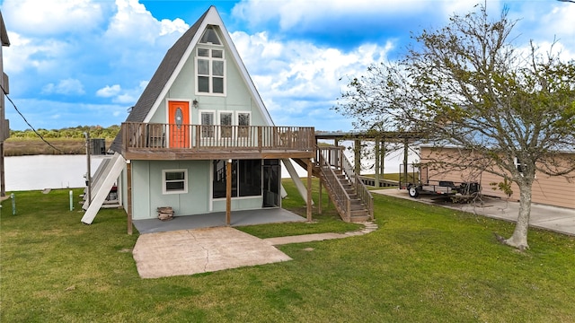 rear view of property with a deck with water view, a yard, and a patio