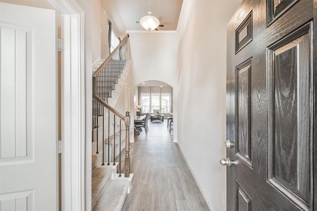 foyer entrance with light hardwood / wood-style floors and ornamental molding