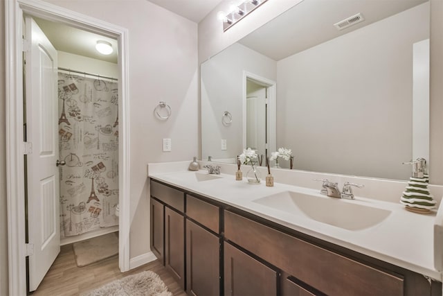 bathroom featuring a shower with shower curtain, hardwood / wood-style floors, and vanity