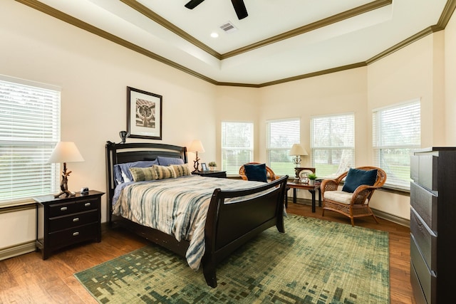 bedroom featuring a raised ceiling, ceiling fan, dark hardwood / wood-style floors, and ornamental molding