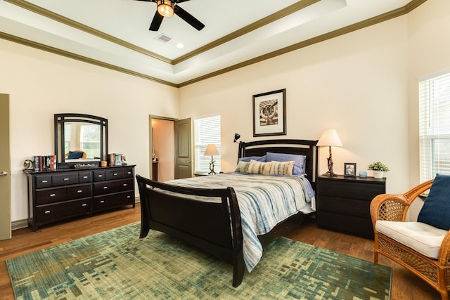 bedroom featuring dark hardwood / wood-style floors, multiple windows, crown molding, and ceiling fan