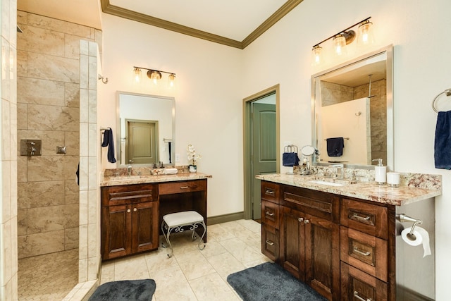 bathroom featuring tile patterned flooring, vanity, ornamental molding, and tiled shower