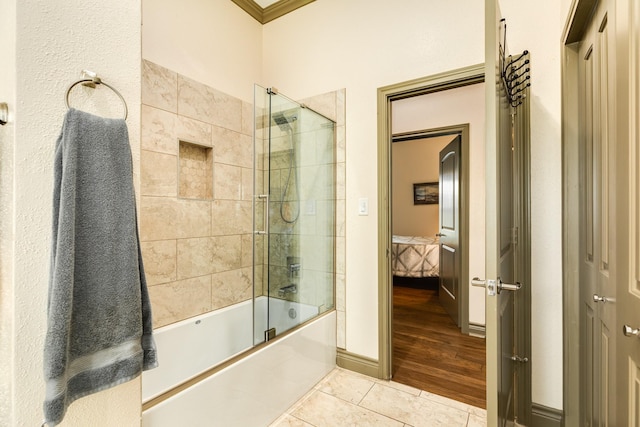 bathroom featuring crown molding, enclosed tub / shower combo, and hardwood / wood-style flooring