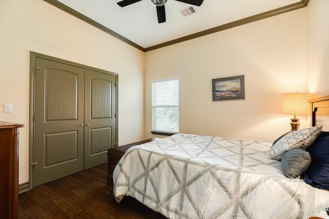 bedroom with ceiling fan, ornamental molding, dark wood-type flooring, and a closet