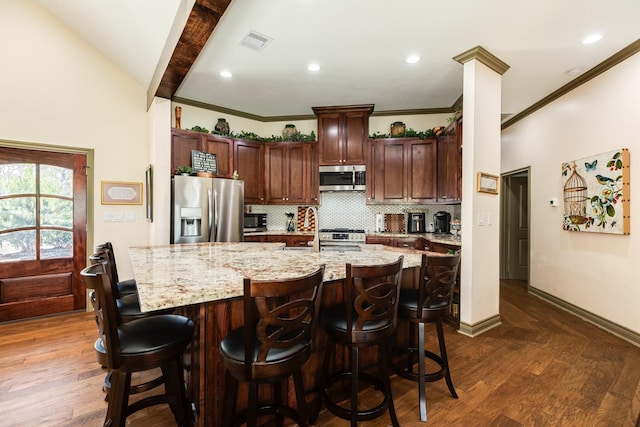 kitchen with decorative backsplash, stainless steel appliances, dark hardwood / wood-style floors, and a breakfast bar area