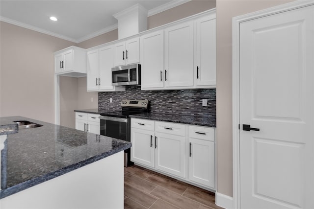 kitchen featuring white cabinets, dark stone countertops, and stainless steel appliances