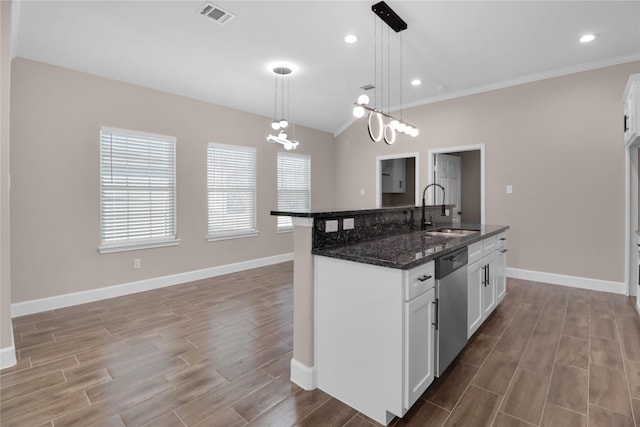 kitchen featuring pendant lighting, a kitchen island with sink, sink, stainless steel dishwasher, and white cabinetry