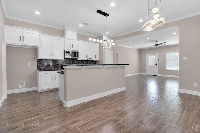 kitchen featuring white cabinetry, ceiling fan, light hardwood / wood-style flooring, and an island with sink