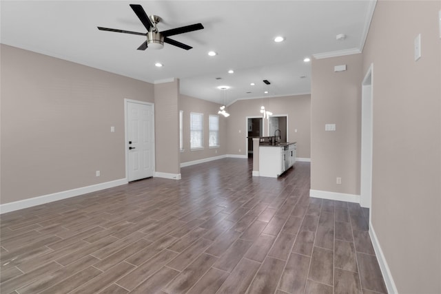 unfurnished living room featuring wood-type flooring, ceiling fan, crown molding, and sink