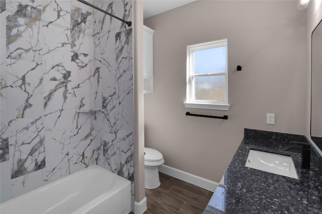 full bathroom with tiled shower / bath, vanity, and toilet