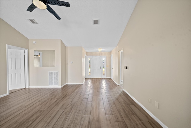 unfurnished living room featuring ceiling fan and lofted ceiling