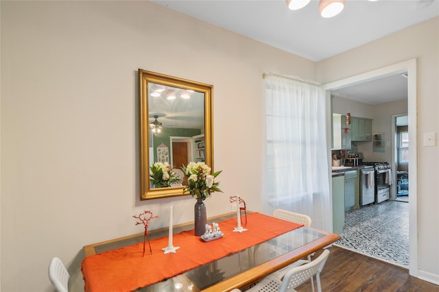 dining space with ceiling fan and dark wood-type flooring