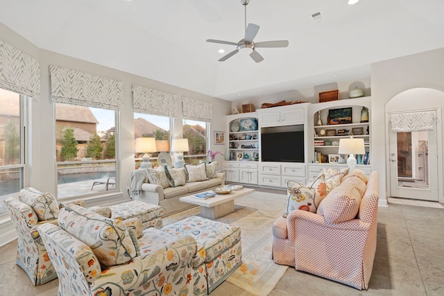 living room featuring high vaulted ceiling, ceiling fan, and built in shelves