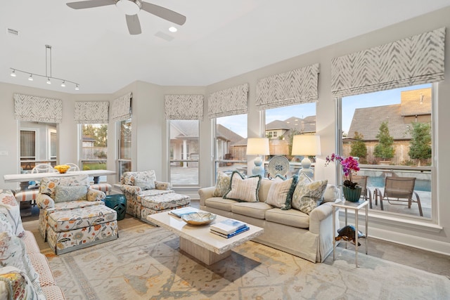 sunroom / solarium featuring track lighting and ceiling fan