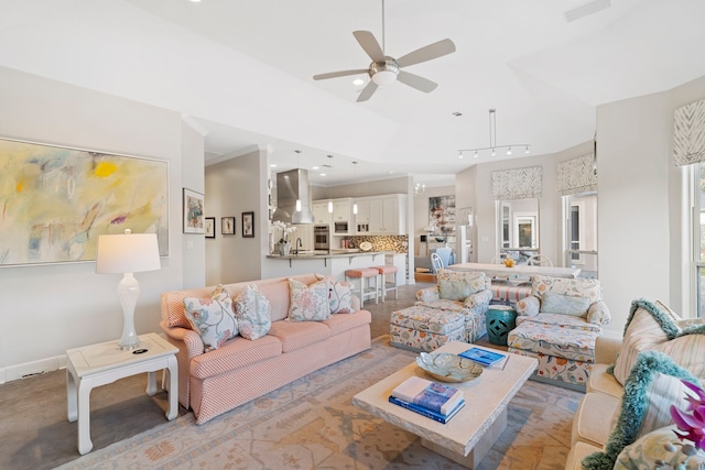 living room with crown molding, sink, and ceiling fan