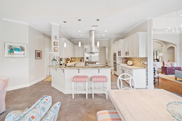 kitchen featuring white cabinetry, decorative light fixtures, light stone counters, and kitchen peninsula