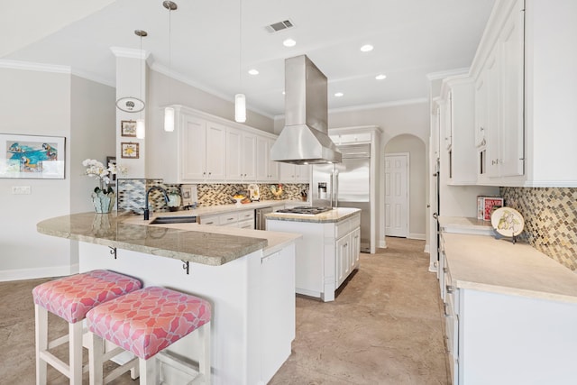 kitchen with sink, island range hood, hanging light fixtures, kitchen peninsula, and white cabinets