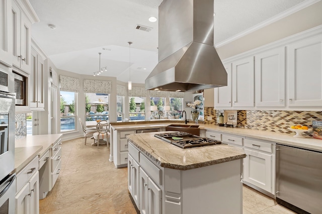 kitchen featuring refrigerator, white cabinetry, a center island, island range hood, and stainless steel gas cooktop