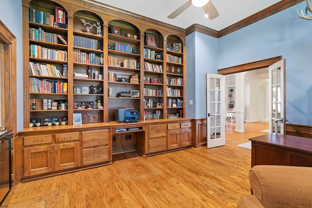 interior space with french doors, built in desk, ornamental molding, ceiling fan, and light hardwood / wood-style floors