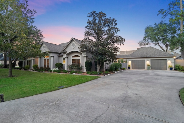 view of front of home with a garage and a lawn