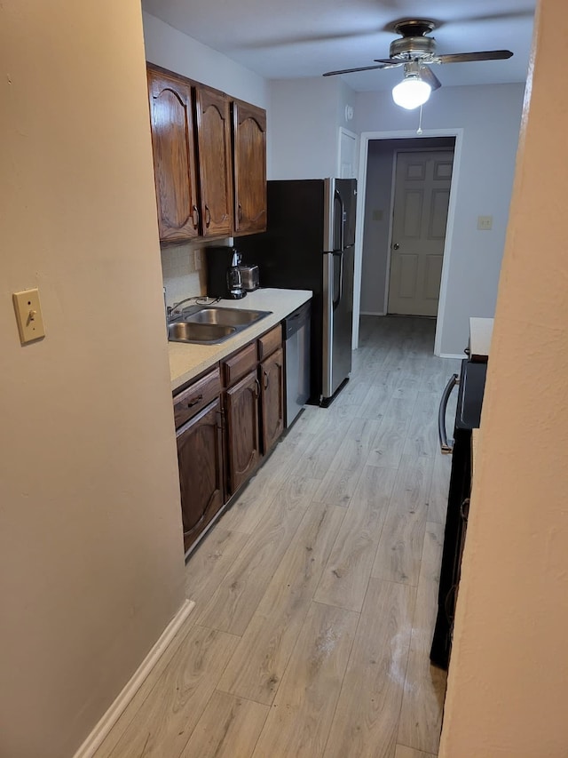 kitchen featuring dark brown cabinets, stainless steel appliances, light hardwood / wood-style flooring, and sink