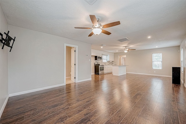 unfurnished living room featuring a textured ceiling, ceiling fan, and dark hardwood / wood-style floors