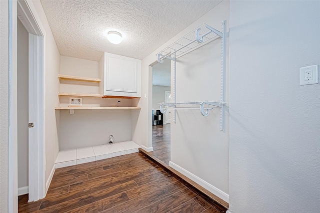 laundry area featuring dark hardwood / wood-style flooring and a textured ceiling