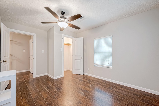 unfurnished bedroom featuring ceiling fan, dark hardwood / wood-style flooring, and a textured ceiling