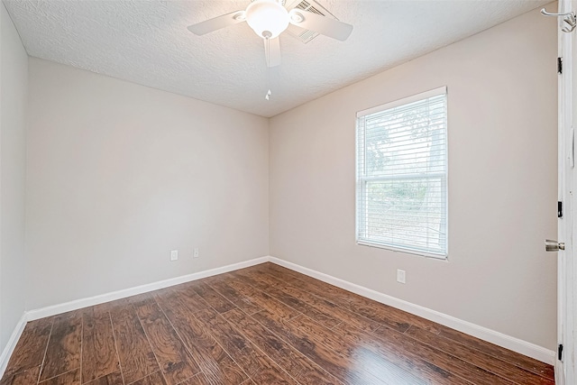 empty room with dark hardwood / wood-style floors and a textured ceiling