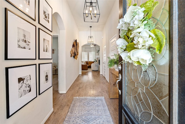 hallway with a chandelier and hardwood / wood-style flooring