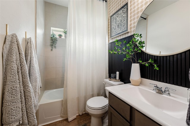 full bathroom with hardwood / wood-style floors, vanity, shower / bath combo, and toilet