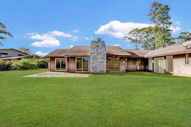 rear view of house featuring a yard and a patio