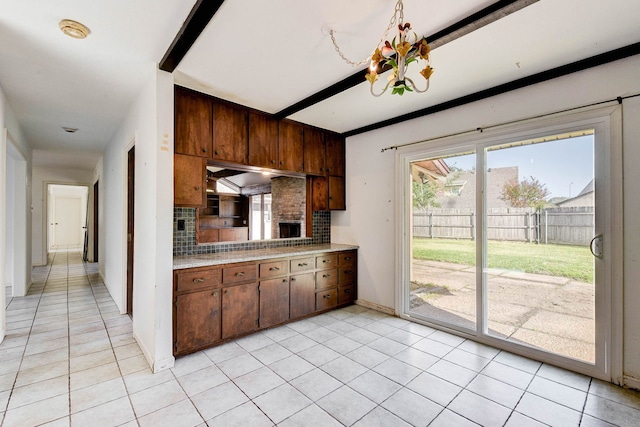 kitchen with backsplash, light tile patterned flooring, and a chandelier