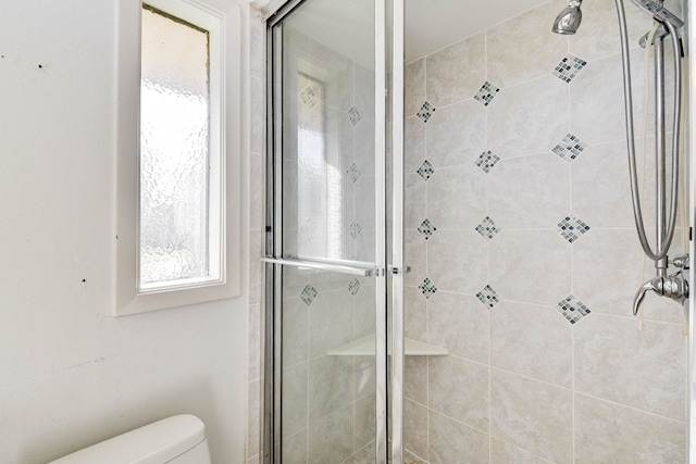 bathroom featuring an enclosed shower and toilet