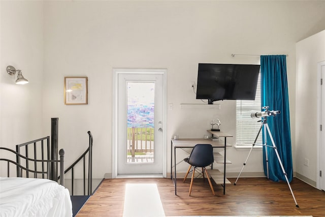 bedroom with hardwood / wood-style floors and access to exterior