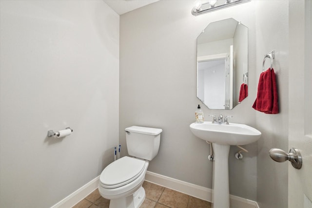 bathroom featuring sink, toilet, and tile patterned flooring