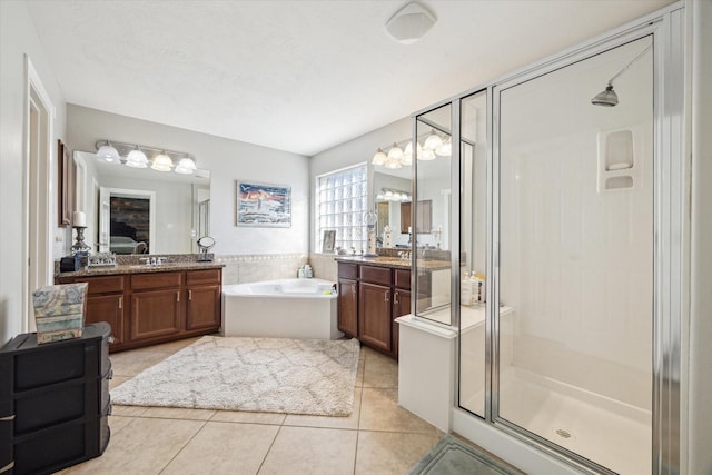 bathroom featuring independent shower and bath, vanity, and tile patterned floors