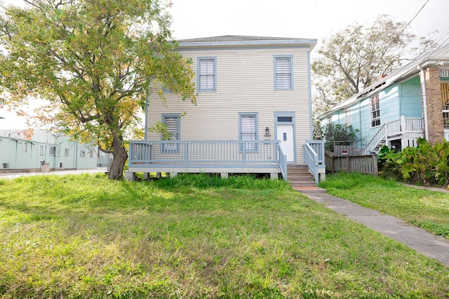 view of front facade with a deck and a front yard