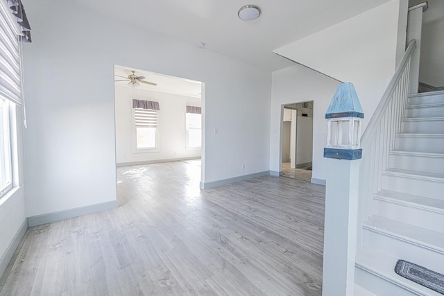 unfurnished living room with ceiling fan and light wood-type flooring