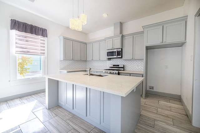 kitchen featuring a center island with sink, backsplash, pendant lighting, and stainless steel appliances