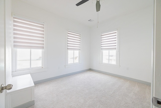 spare room with light carpet, plenty of natural light, and ceiling fan