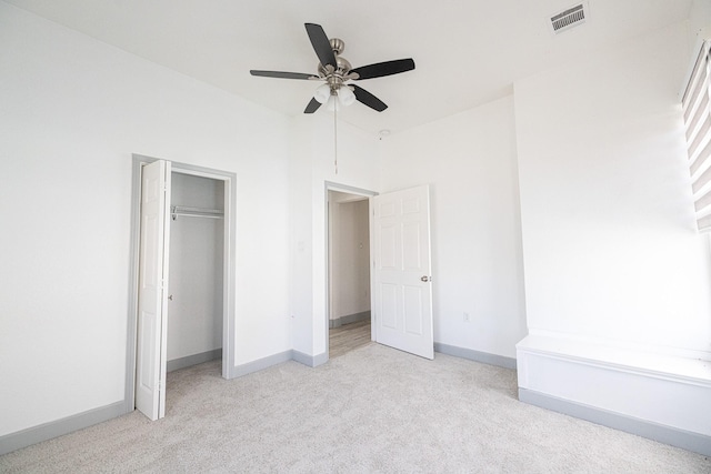 unfurnished bedroom with ceiling fan, light colored carpet, and a closet