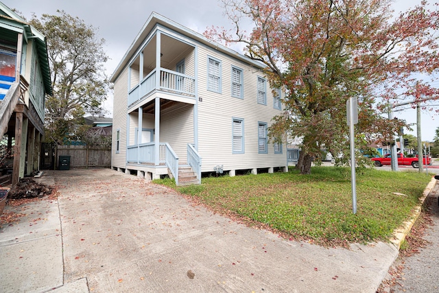 view of property exterior with a yard and a balcony