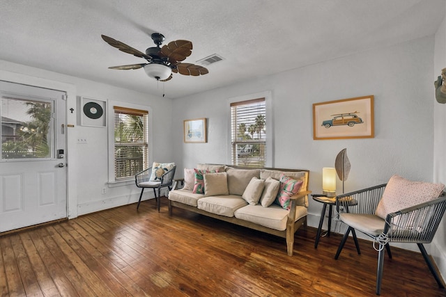 living room with dark hardwood / wood-style floors, a healthy amount of sunlight, a textured ceiling, and ceiling fan