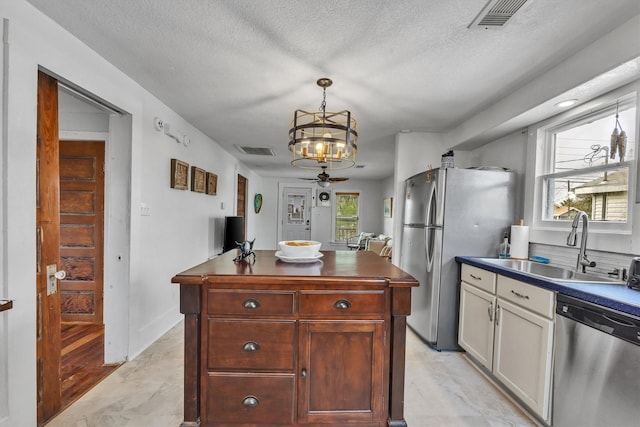 kitchen with plenty of natural light, ceiling fan, a textured ceiling, and appliances with stainless steel finishes